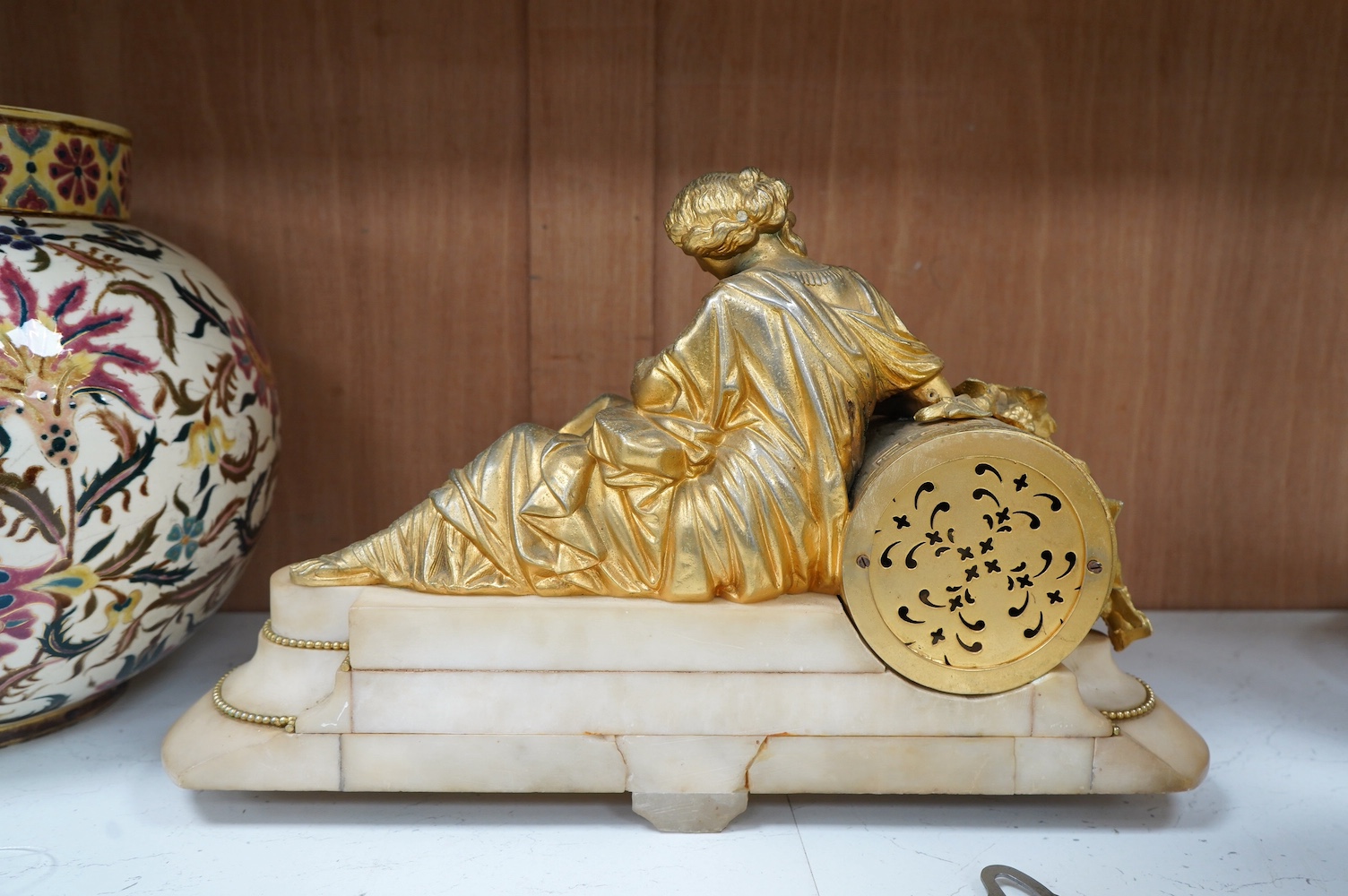 A 19th century white marble mantel clock with enamel dial, surmounted with a gilt spelter figure, with key, 46cm wide. Condition - fair, untested